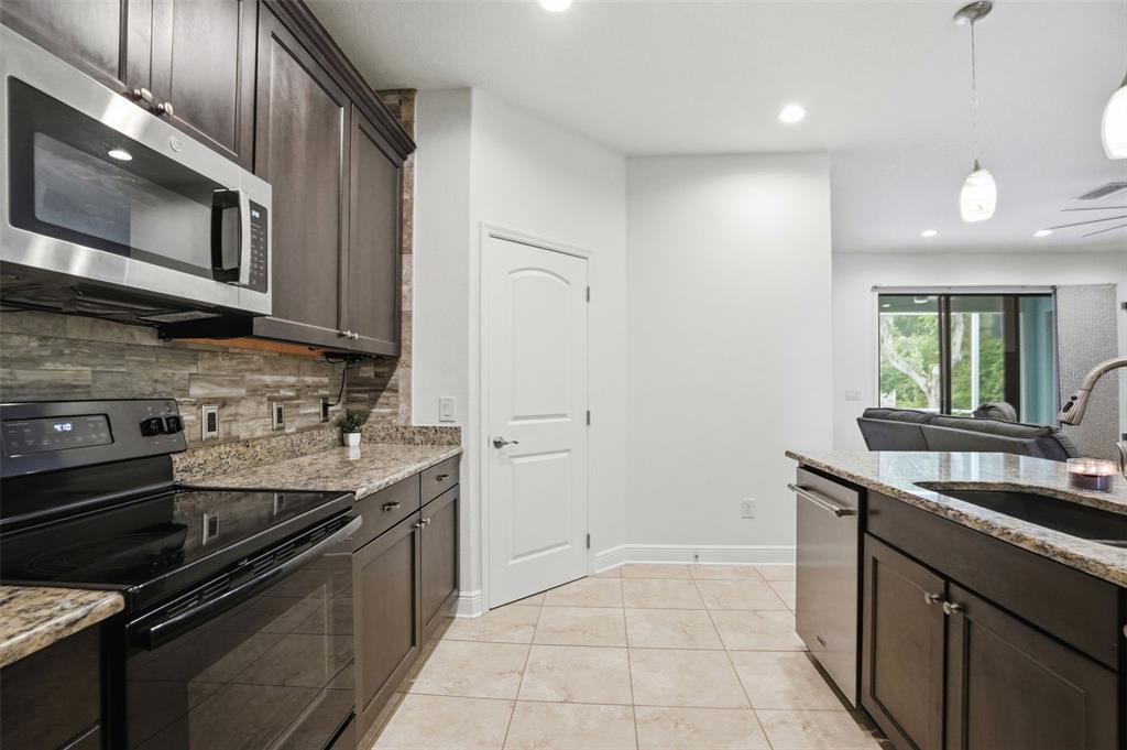 12417 Coralbean Court New Port Richey, FL 34654 - Photo 16 of 64 a kitchen with stainless steel appliances granite countertop a sink and a stove