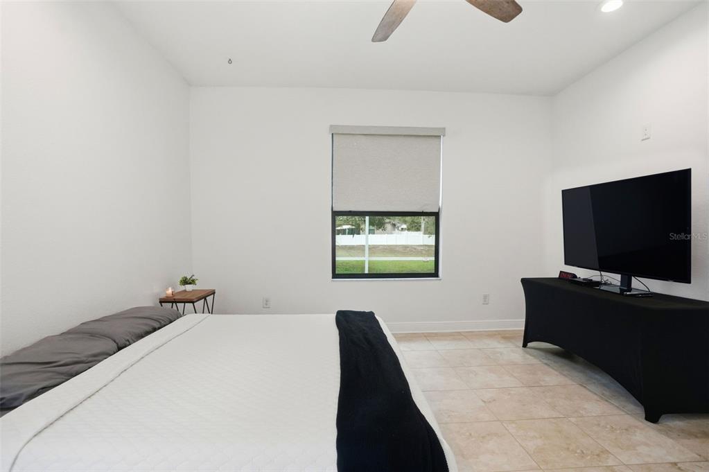 12417 Coralbean Court New Port Richey, FL 34654 - Photo 20 of 64 a bedroom with a bed and a flat screen tv