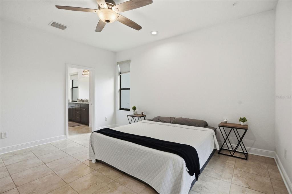 12417 Coralbean Court New Port Richey, FL 34654 - Photo 21 of 64 a bedroom with a bed and a ceiling fan
