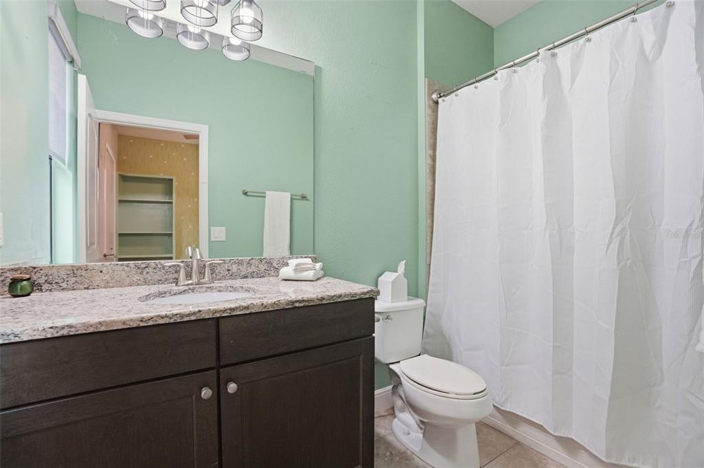 12417 Coralbean Court New Port Richey, FL 34654 - Photo 38 of 64 a bathroom with a granite countertop sink toilet and mirror