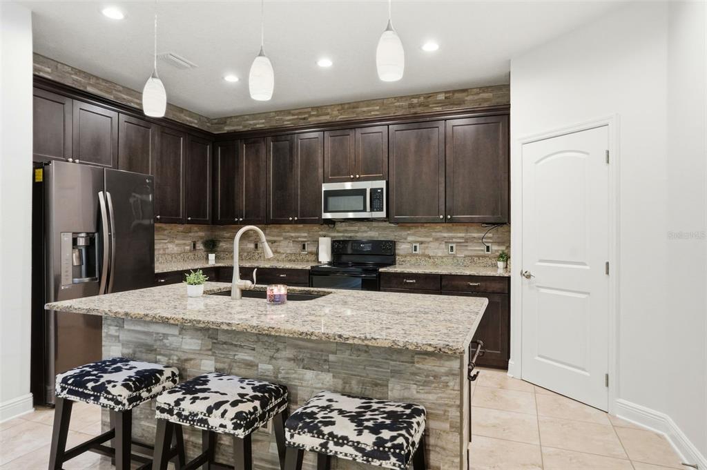 12417 Coralbean Court New Port Richey, FL 34654 - Photo 4 of 64 a kitchen with stainless steel appliances granite countertop a stove refrigerator sink and microwave