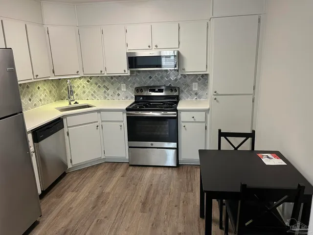 a kitchen with a stove a refrigerator and a table