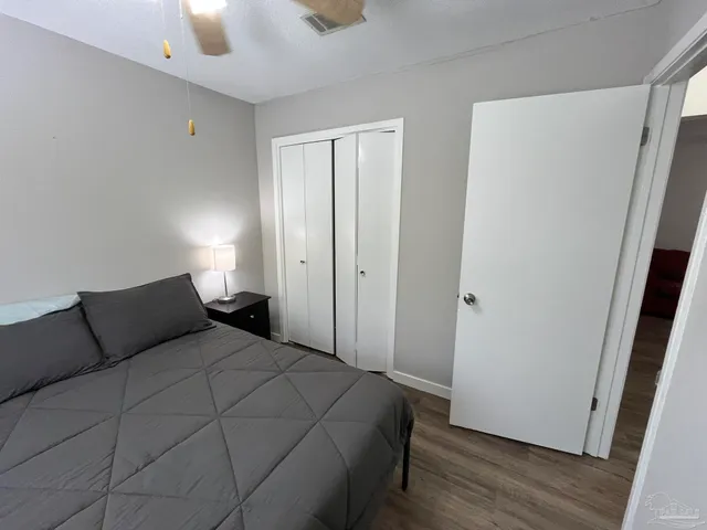 a bedroom with a bed and wooden floor