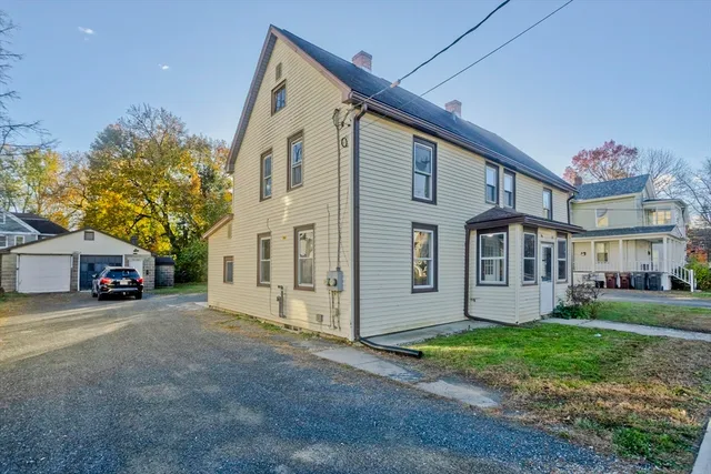 a view of a house with a yard and pathway