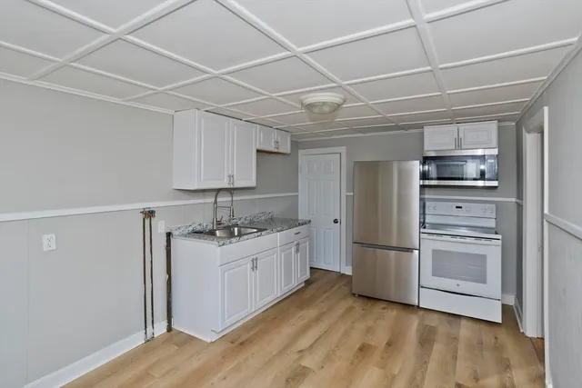 a kitchen with a sink appliances and cabinets