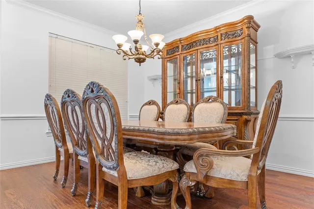 a view of a dining room with furniture a chandelier and wooden floor