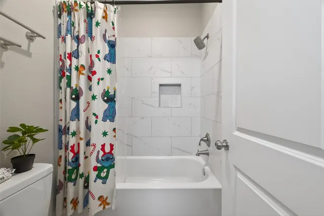 a bathroom with a bathtub and shower curtain
