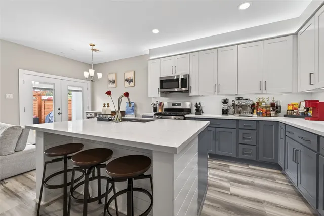 a kitchen with kitchen island granite countertop white cabinets and stainless steel appliances