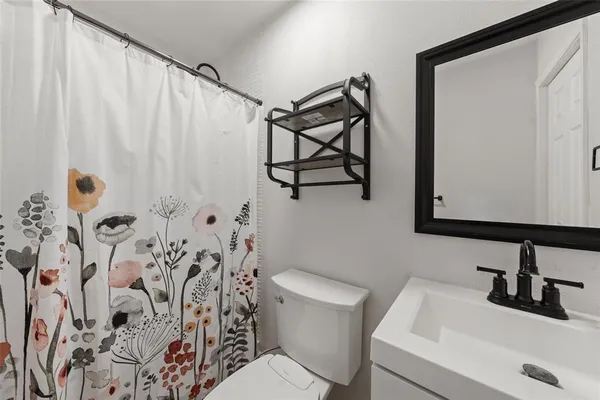 a bathroom with a sink and mirror with toilet