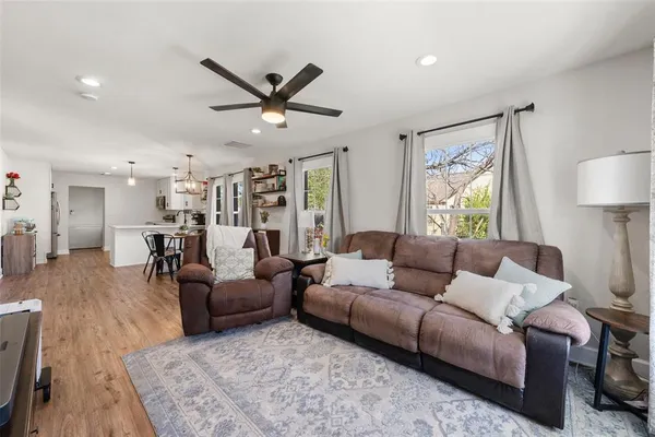 a living room with furniture and a wooden floor