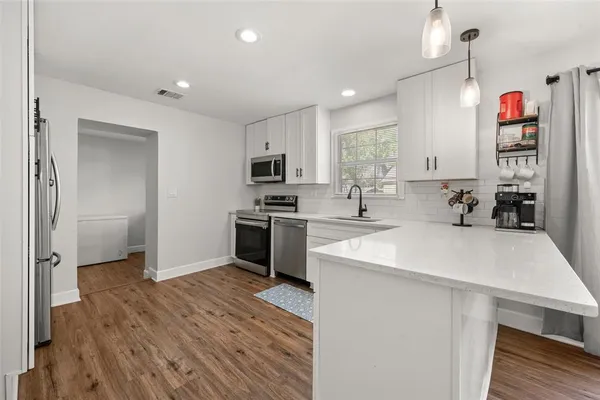 a kitchen with granite countertop a sink appliances and cabinets