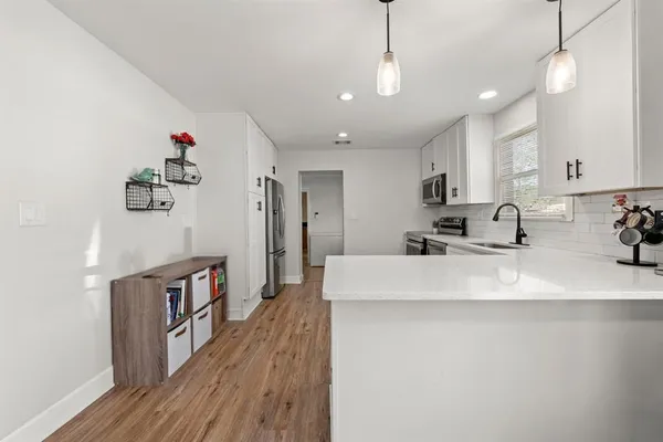 a view of a kitchen with kitchen island stainless steel appliances sink microwave and cabinets