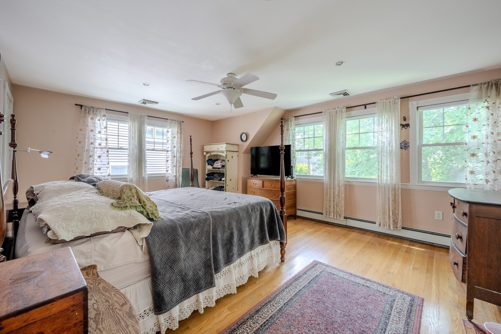 75 Ridge Street Arlington, MA 02474 - Photo 19 of 33 a spacious bedroom with a large bed and a chandelier