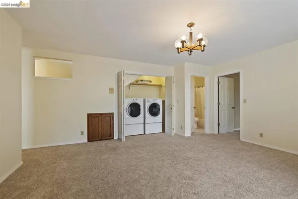 a view of a livingroom with an empty room and chandelier fan