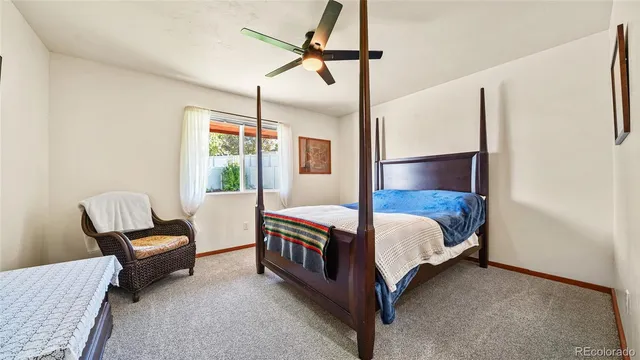 a bedroom with a bed window and chair