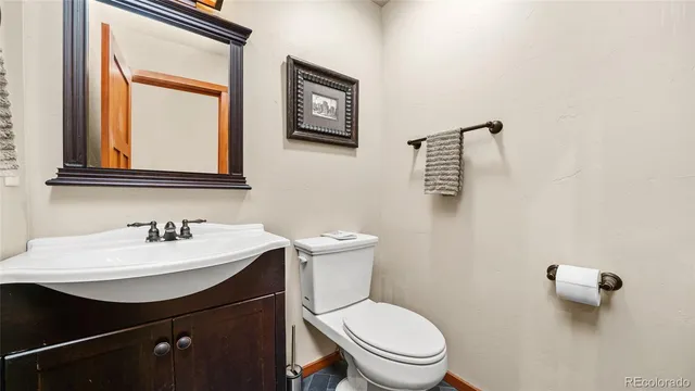 a bathroom with a sink a toilet and mirror