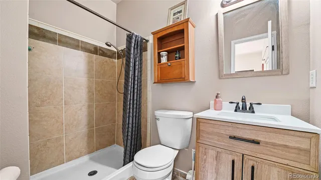 a bathroom with a sink toilet vanity and shower