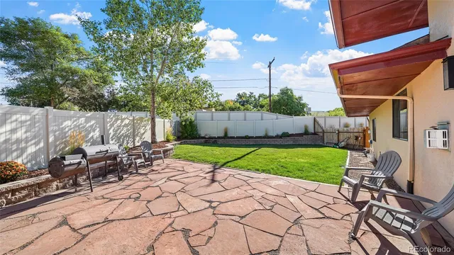 a view of backyard with table and chairs and a barbeque