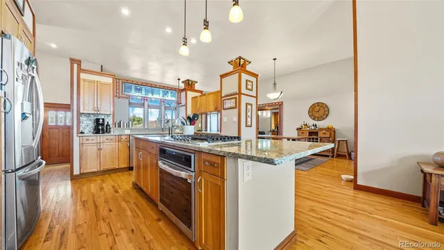 a kitchen with stainless steel appliances granite countertop a sink cabinets and wooden floor