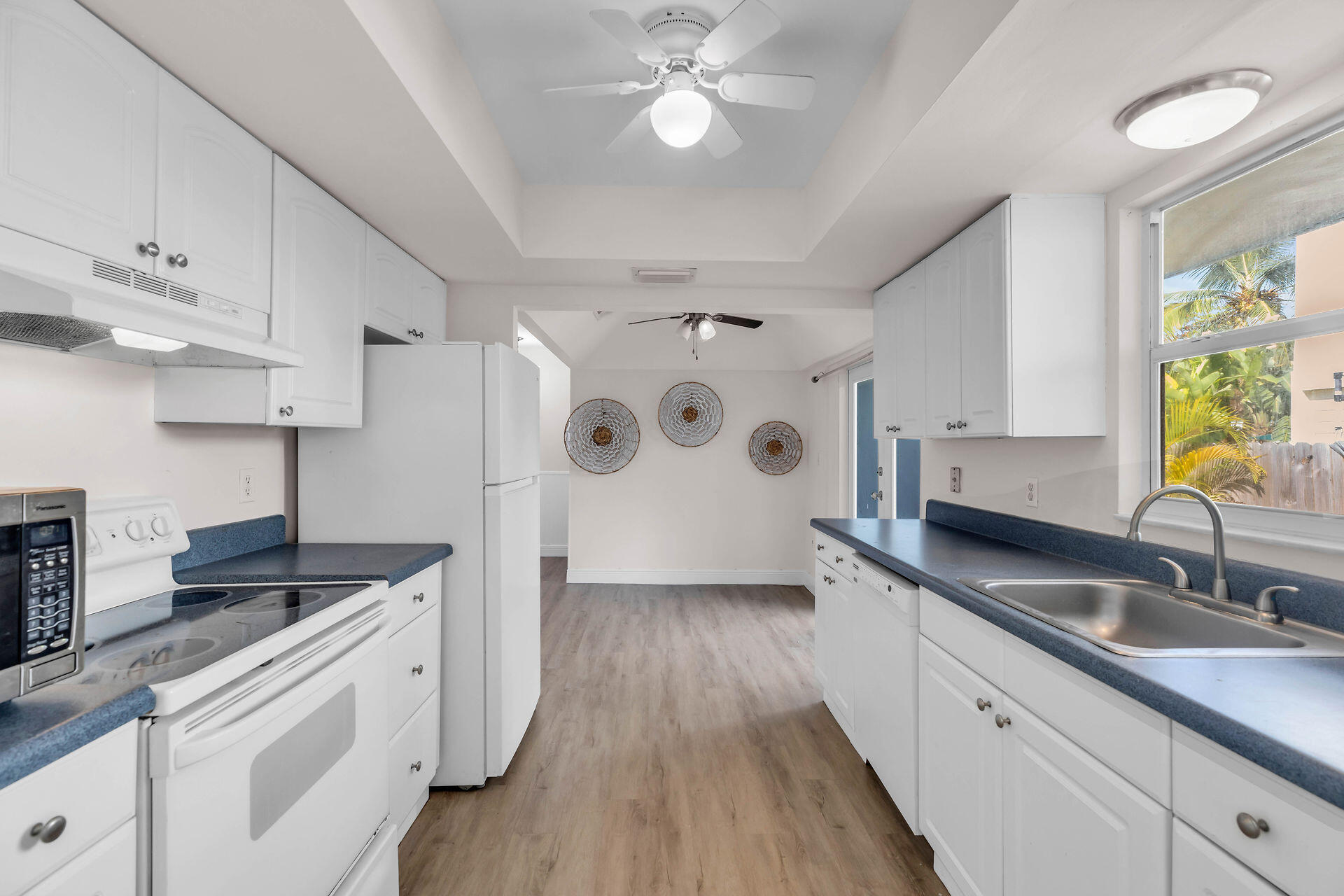 37 Orange Drive Key Largo, FL 33037 - Photo 9 of 32 a kitchen with granite countertop a sink stainless steel appliances white cabinets and wooden floor
