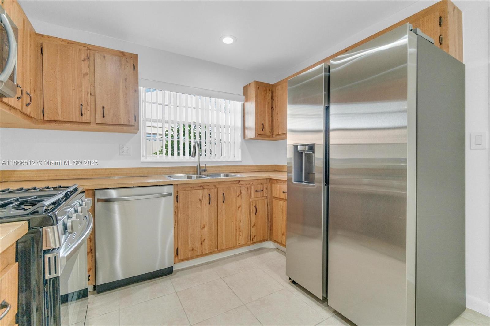 13440 Southwest 81st Street Miami, FL 33183 - Photo 4 of 23 a kitchen with a refrigerator a sink and cabinets