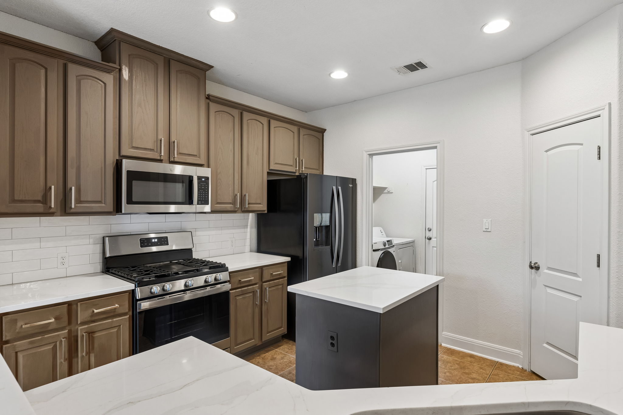 114 Aria Ridge, Unit 802 Lakeway, TX 78738 - Photo 7 of 37 A well-appointed kitchen features a central island, gas range, and ample cabinetry for culinary pursuits.