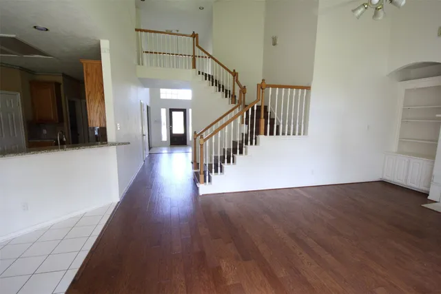 a hallway with wooden floor windows and stairs