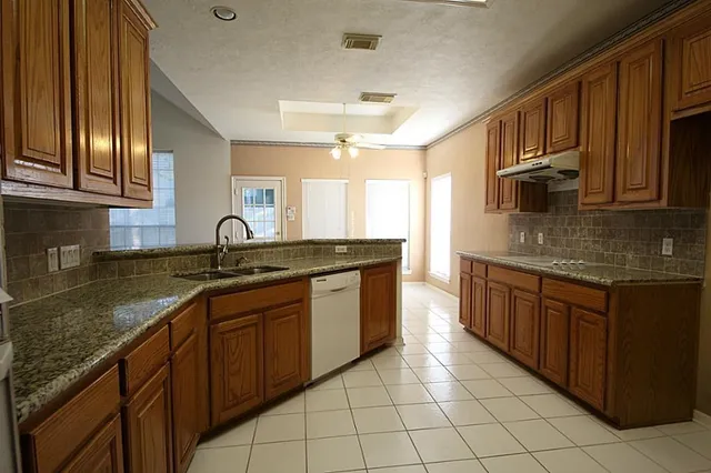 a kitchen with stainless steel appliances granite countertop a sink stove and cabinets
