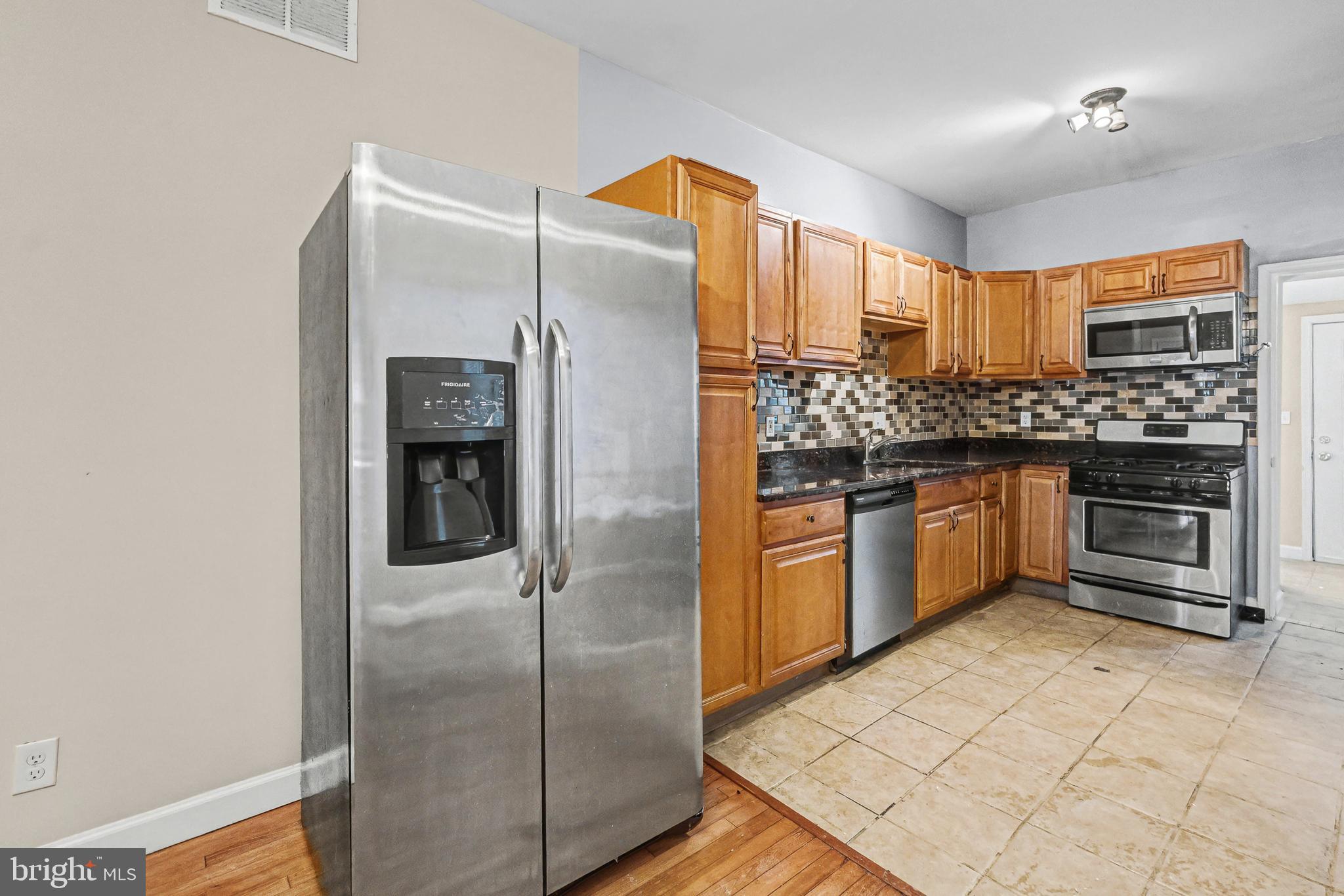 407 West 28th Street Baltimore, MD 21211 - Photo 3 of 30 a kitchen with stainless steel appliances granite countertop a refrigerator and a stove