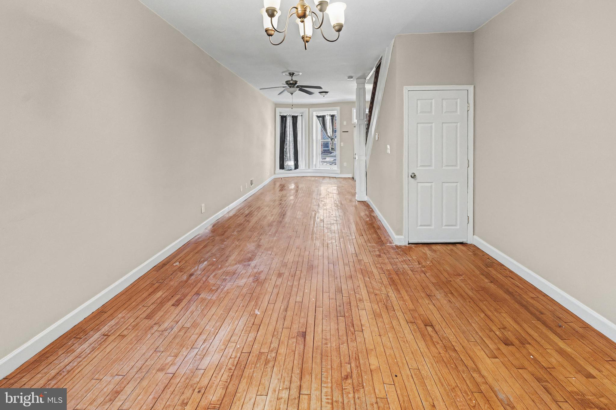 407 West 28th Street Baltimore, MD 21211 - Photo 8 of 30 a view of a hallway with wooden floor and a chandelier