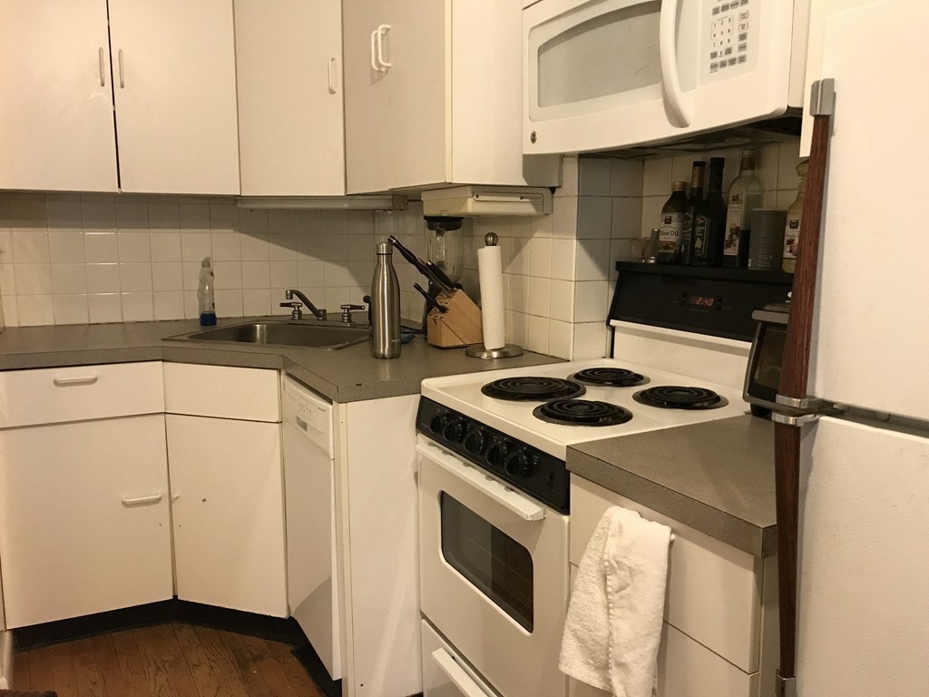 43-43A Grove Street, Unit 2 Boston, MA 02114 - Photo 2 of 6 a kitchen with a stove and a microwave