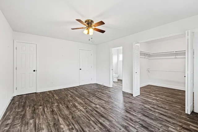 a bathroom with a toilet sink double vanity and mirror