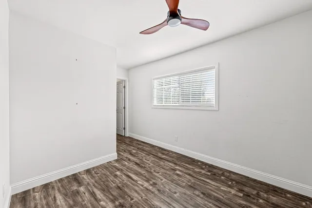 a view of a room with wooden floor staircase and a ceiling fan