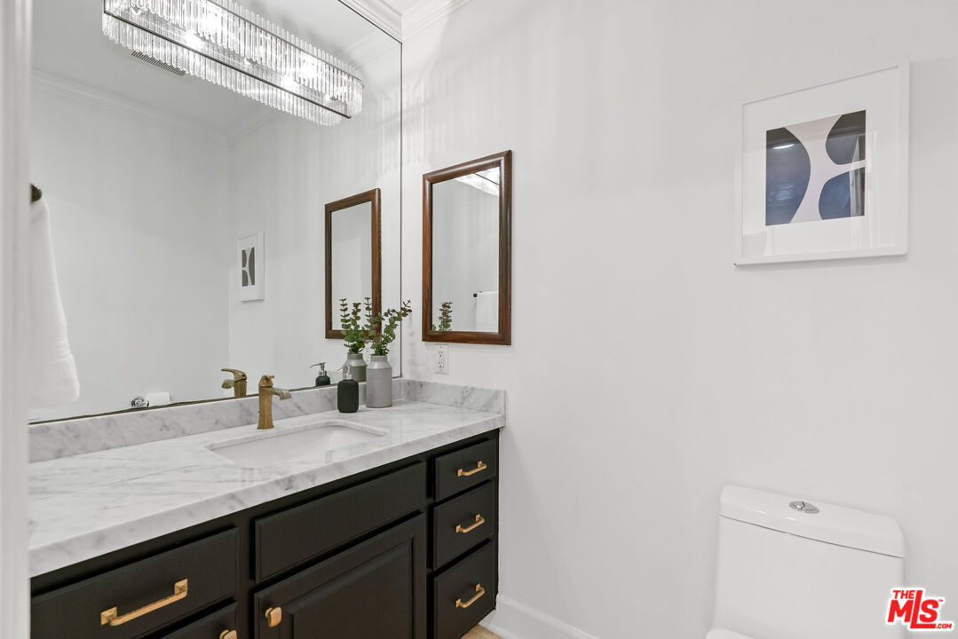 7112 Rindge Avenue Playa del Rey, CA 90293 - Photo 9 of 39 a bathroom with a granite countertop sink a mirror and vanity