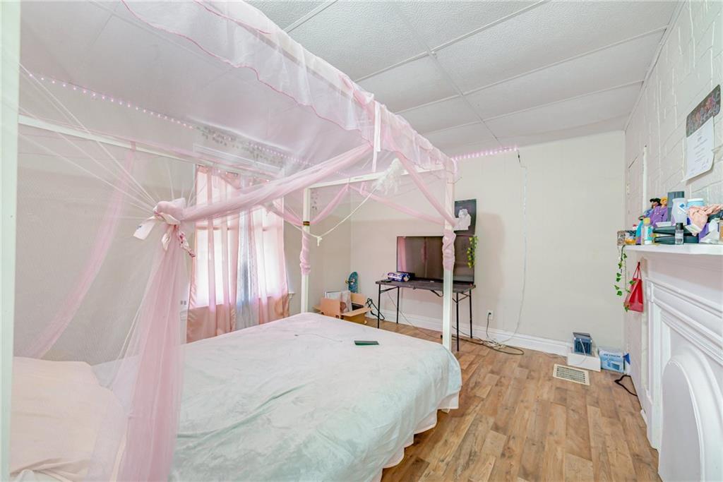 247 Marion Street McKees Rocks, PA 15136 - Photo 14 of 19 a bedroom with a bed and a wooden floor