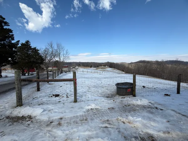 a view of a dry yard with wooden fence