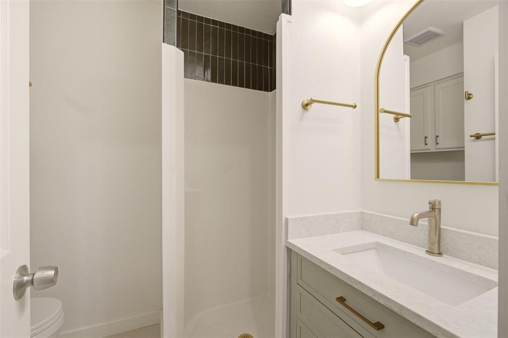 908 Isbell Road, Unit A Fort Worth, TX 76114 - Photo 21 of 28 Bathroom featuring a vanity with an integrated sink, light-toned countertop, and brass hardware