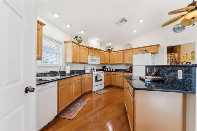 a large kitchen with stainless steel appliances granite countertop a stove a sink and a microwave
