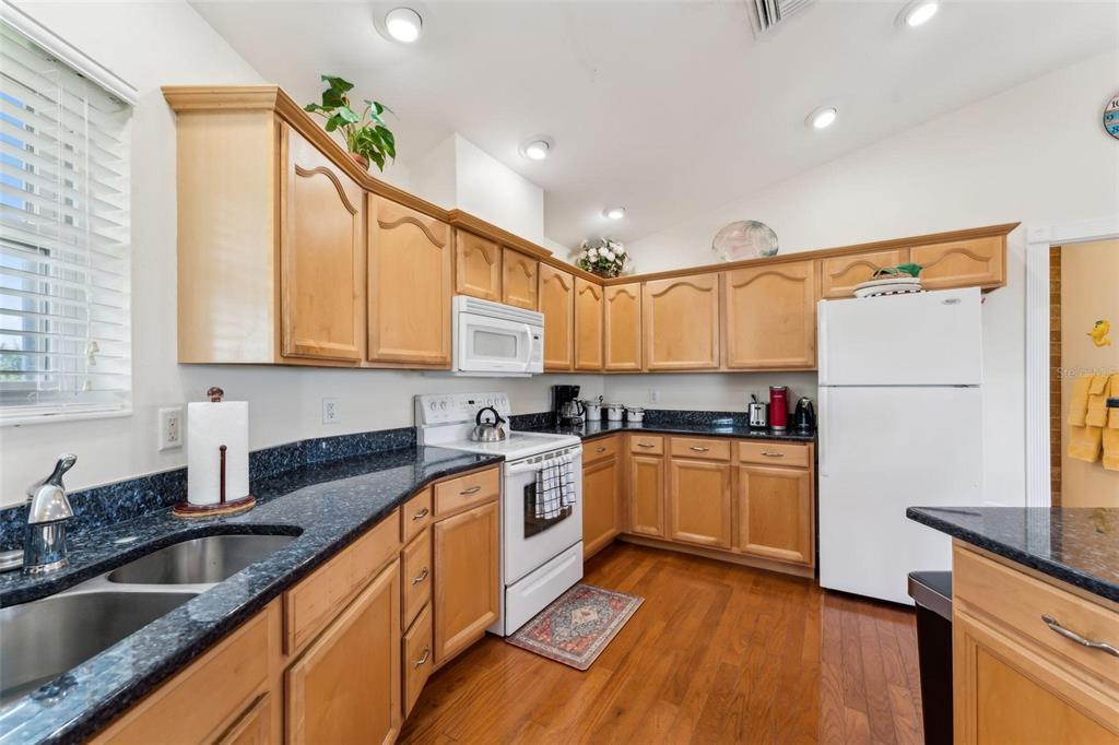 16361 Stringfellow Road Bokeelia, FL 33922 - Photo 16 of 26 a kitchen with granite countertop a sink a counter top space stainless steel appliances and cabinets