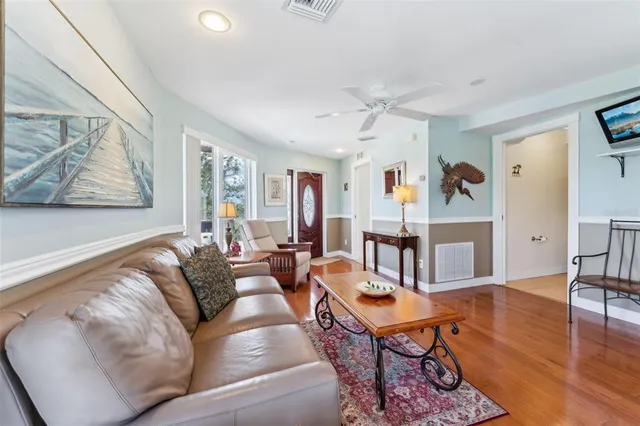 a living room with furniture kitchen view and a large window