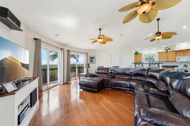 a living room with furniture kitchen view and a large window