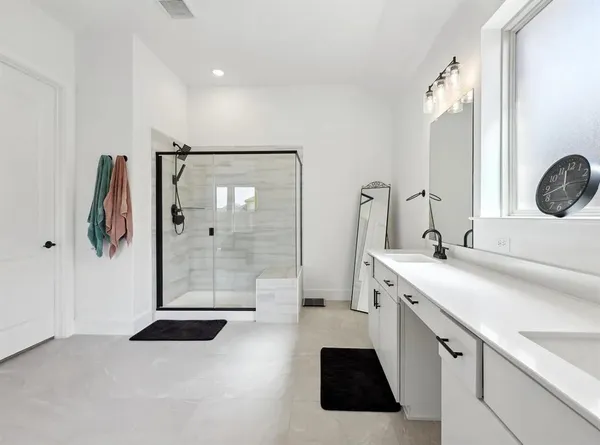 a bathroom with a double vanity sink a mirror a shower and vanity