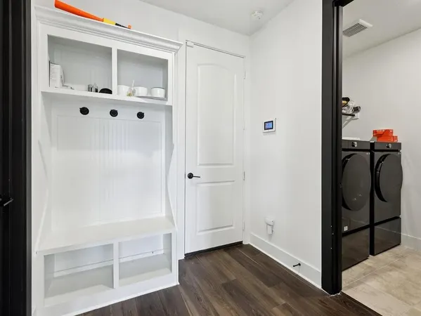 a view of a hallway with wooden floor and closet