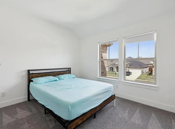 a bed sitting in a bedroom next to a window
