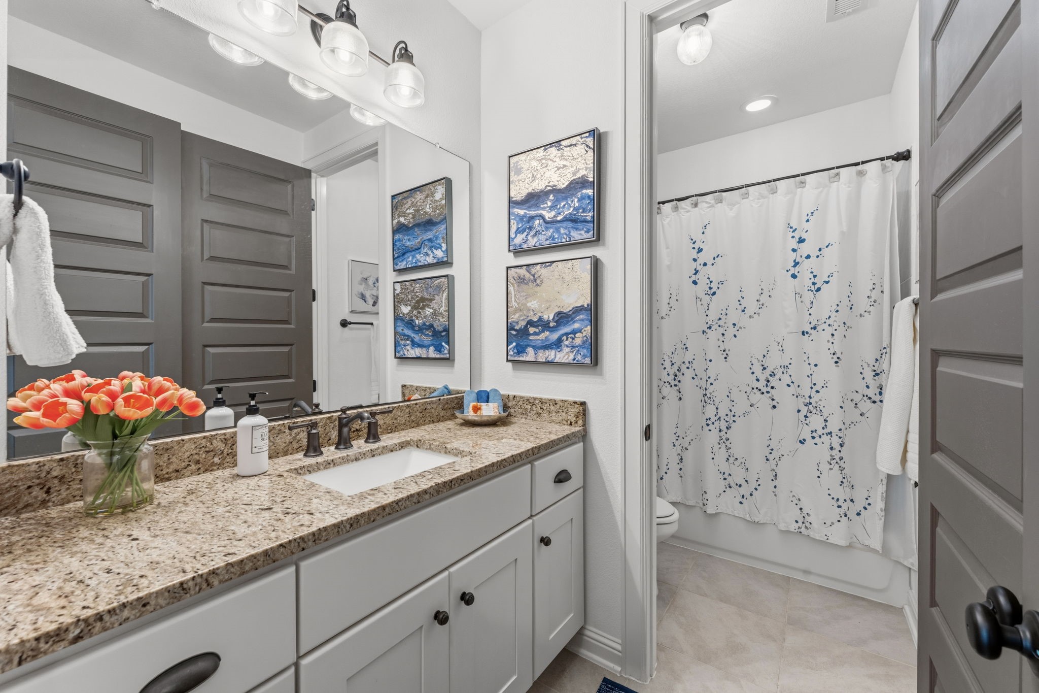 248 Fire Sky Road Huntsville, TX 77340 - Photo 27 of 36 Upstairs full bath features a generous vanity with granite countertop and a tub/shower combination with decorative tile surround.