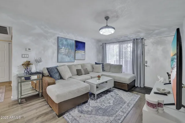 a living room with furniture and wooden floor
