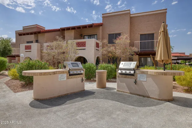 a view of a patio with couches chairs potted plants and a building