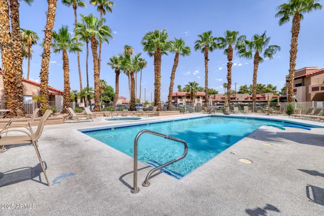 a row of palm trees and swimming pool in the backyard of a house