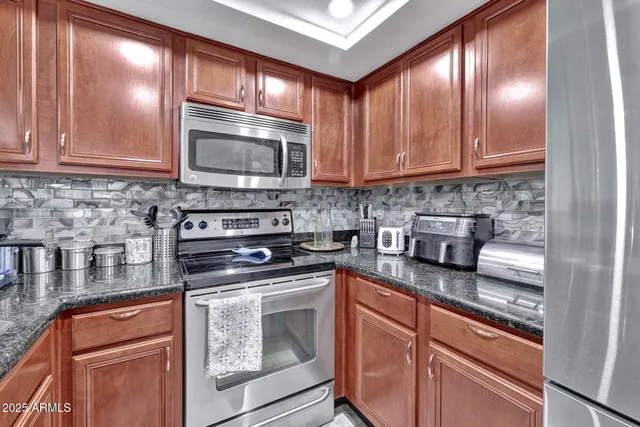 a kitchen with stainless steel appliances granite countertop a stove a sink and a microwave