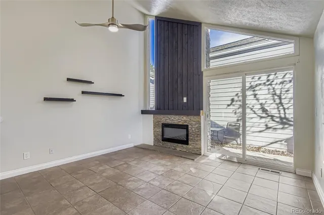 a view of an empty room with a fireplace and a window
